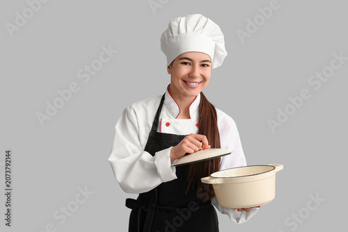 Young female chef with cook...