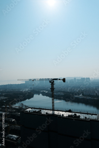 Construction crane over city river skyline
