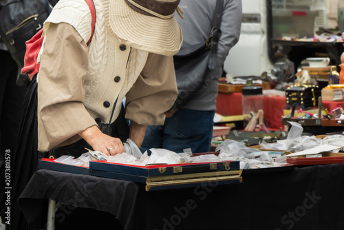 flea market shopper browsing small items at street market