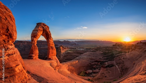A Breathtaking View Of A Natural Delicate Red Rock Arch Against A Vibrant Sunset Sky Stunning Scenic World Landscape Wallpaper Background