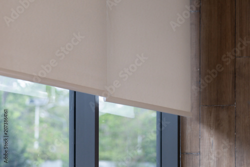 Modern window with white blinds against yellow wall, natural light.