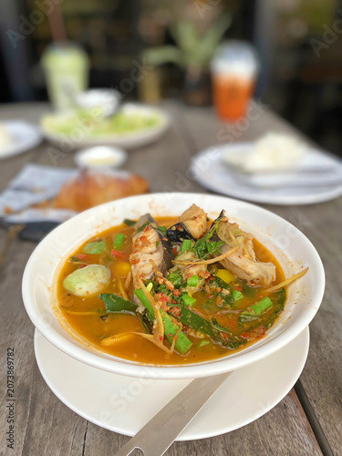 Spicy Thai fish soup with fresh herbs, vegetables, and rich aromatic broth served as a traditional seafood meal.