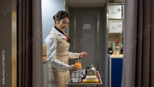 Photos Smiling female flight attendant preparing refreshments drinks on catering servic