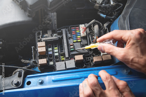 Technician checking car fuse. Car maintenance