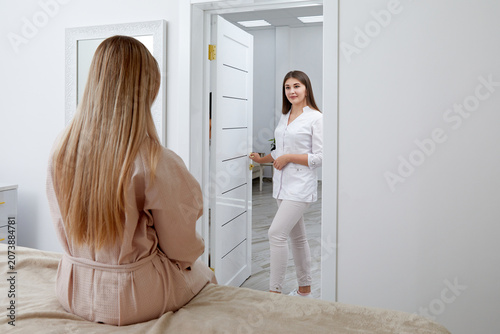 Slika na platnu Professional touch: Female cosmetologist prepares to start session with seated p