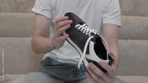 Demonstration of design of new leather sneakers, Shopper inspecting new shoes after unpacking at home