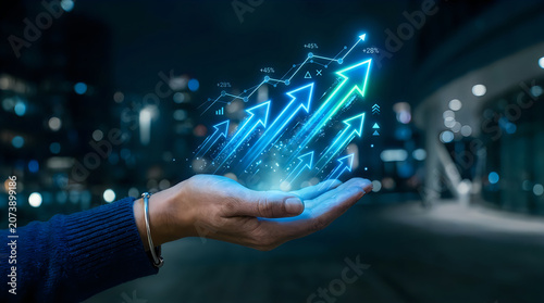 Businessman holding a glowing holographic chart with rising arrows showing financial growth and success