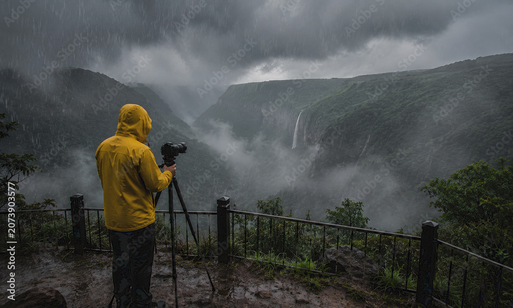 Naklejka premium Photographer Capturing Meghalaya Monsoon Landscape from Scenic Viewpoint