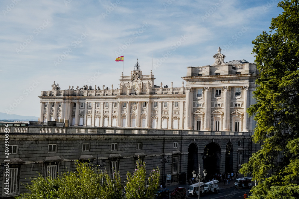 Fototapeta premium Royal palace of Madrid facade with spanish flag, Spain
