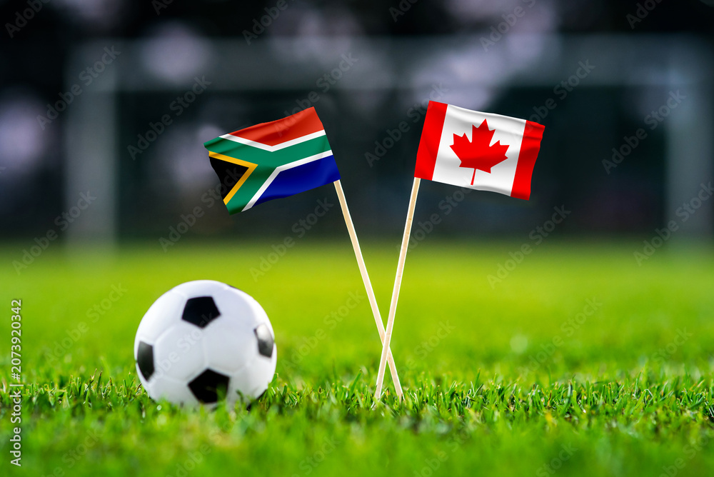 Obraz premium South Africa vs Canada, national flags before international football tournament Round of 32 match, football on green grass with goal in the background, Inglewood, California, USA, June 28, 2026