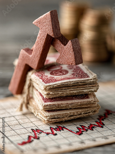 An upward and downward arrow intersecting over a stack of bond certificates and a graph of interest rate fluctuations represents the volatile nature of bond investments. The image is designed with