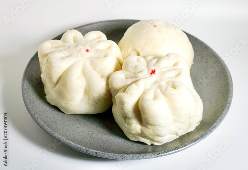 Obraz na płótnie Three baozi dimsum breads on gray plate isolated on horizontal white background