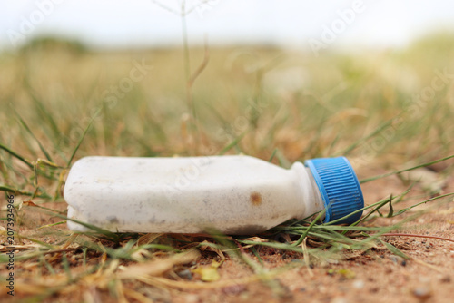 Old plastic bottles left on the ground, grass, old medicine bottles, environmental pollution.