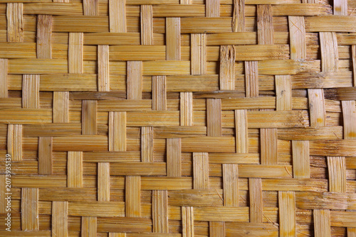 Close-up of woven bamboo texture with natural craftsmanship, creating rustic handmade pattern for backgrounds and design projects.