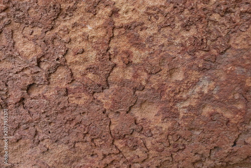 close-up image of rough, brown stone surface with natural patterns, ideal for use as natural backdrop for nature-themed and design projects.