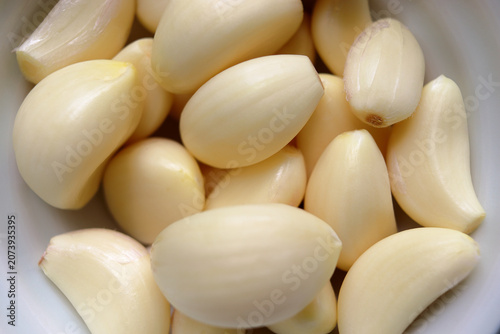 Fresh peeled garlic cloves in a close-up macro view, showcasing natural texture and healthy organic ingredients for cooking and food preparation.