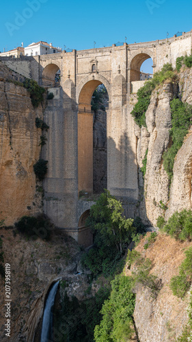 Fotografía vertical del famoso puente de arco y piedra de 98 metros de altura en la villa de Ronda, España