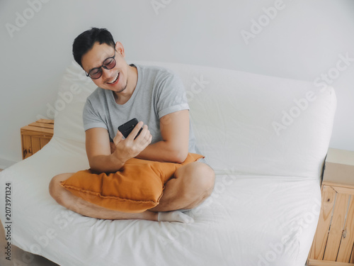Asian man individual enjoys cozy moment with social in mobile phone.