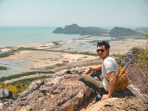 Person on rocky ledge selecting best shot amid sunny environment