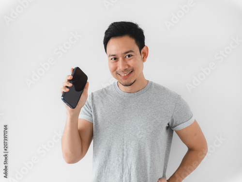 Individual with grey tshirt demonstrating device with bright smile