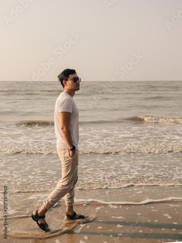Male walking with assurance beside gentle ocean waves during retreat