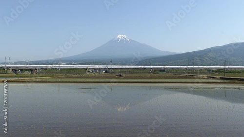 田植え後の水田に映り込む富士山と新幹線および農作業中のトラクターのリアルタイム映像（広角、フィックス）
