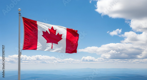 Canadian flag waving in wind against blue sky with white clouds in daylight