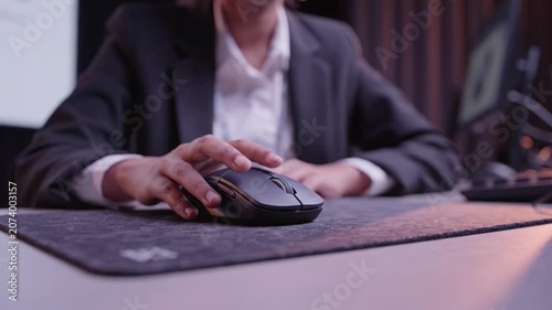 A focused individual operating a computer mouse, showcasing attention to detail and concentration in a professional setting during a digital presentation or work.