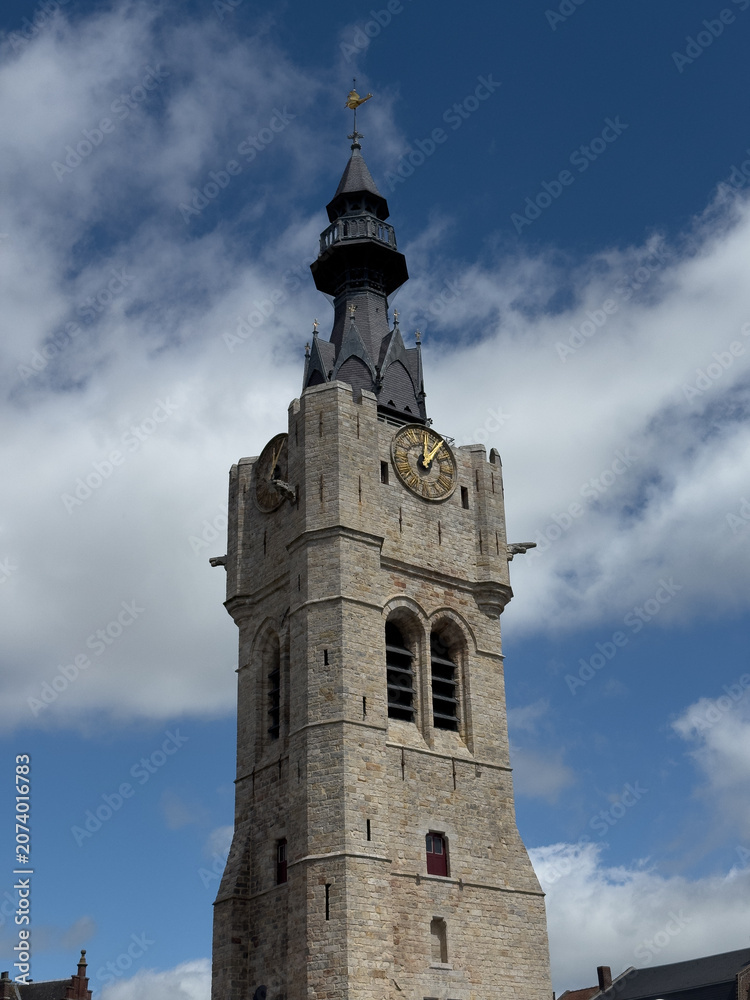 Obraz premium Historic Bethune belfry clock tower under blue cloudy sky