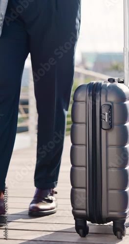 Business travel, legs and hand with suitcase in city, walking and lawyer on urban street or journey. Outdoor, attorney and person with international career opportunity, feet and commute with luggage