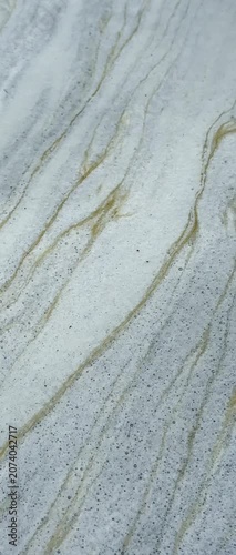 Close-up of naturally formed foam drifting slowly across the water surface, creating unique abstract textures and elegant flowing patterns for creative backgrounds and motion graphics.