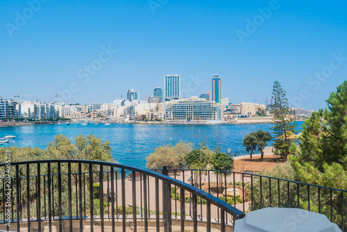Independence Garden railings, seaside promenade park, and St. Julian's in the background, Sliema MALTA