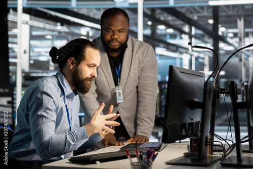 Foto Data center technicians verify firewall configurations and vulnerability scans while reviewing server security