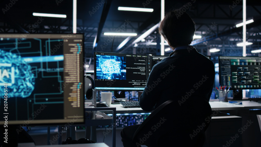 Fototapeta premium Data center engineer reviews artificial intelligence systems and machine learning processes inside a data center.