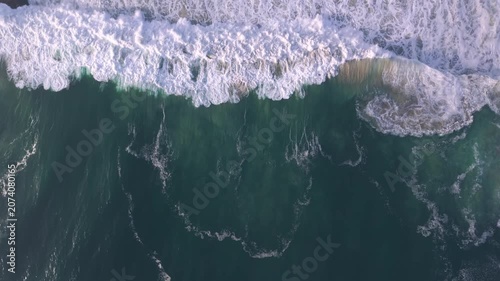 Aerial overhead waves breaking on the coastline