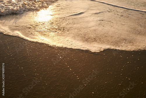 Tableau sur toile CorfuSanfte Wellen und weiße schäumende Brandung am Sandstrand auf Korfu im warmen goldenen Licht des Sonnenuntergangs