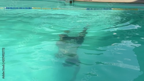 Video of a man swimming in a modern swimming pool. Healthy lifestyle and fitness concept representing physical activity, endurance, recreation and aquatic sports.