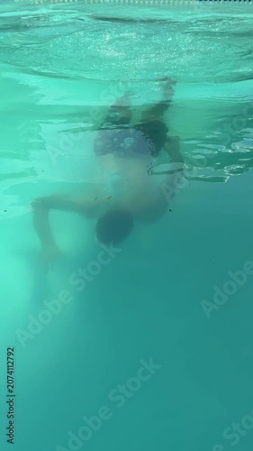 Video of a man swimming in a modern swimming pool. Healthy lifestyle and fitness concept representing physical activity, endurance, recreation and aquatic sports.
