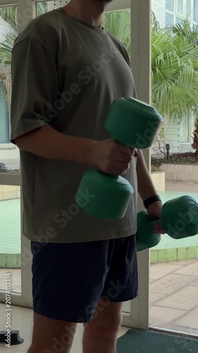 Video of a man performing dumbbell exercises in a modern gym. Fitness and strength training concept representing an active lifestyle, muscle building and personal health.