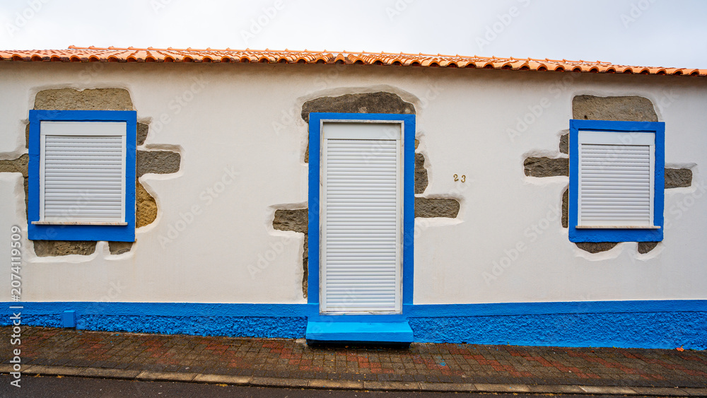 Obraz premium White house facade with blue outlines, typical of Santa Cruz das Flores, Flores Island in the Azores, Portugal.