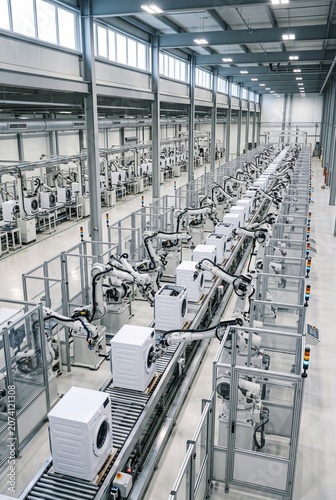 Automated factory assembly line with robotic arms manufacturing washing machines in a modern industrial facility