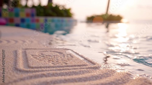 A tranquil summer scene featuring a poolside view, soft sand embossed with a logo, vibrant flower, and warm sunset casting a peaceful ambiance.