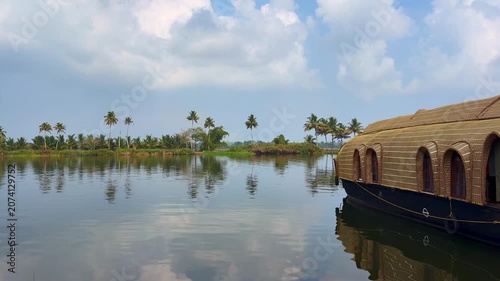 Traditional houseboats docked along the tranquil backwaters of Kerala, surrounded by lush tropical scenery