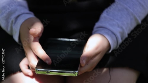 child's finger scrolling on a smartphone screen, symbolizing children's internet use, digital habits, online safety, parental control, and cybersecurity awareness in today's connected world