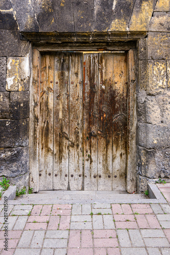 Worn wooden door against stone wall