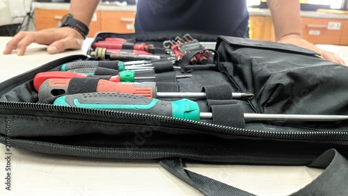 Close-up of a professional technician's portable tool kit neatly organized on a workbench, featuring screwdrivers, hex keys, and hand tools ready for maintenance, repair, and engineering tasks