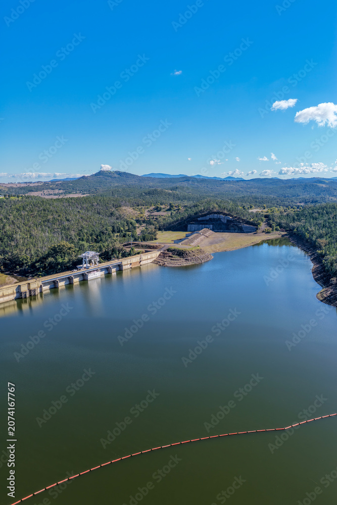 Fototapeta premium Aerial vertical view showcasing the Lake Keepit dam wall, engineering infrastructure and surrounding rural landscape, highlighting the scale of the reservoir and its water storage in NSW, Australia.