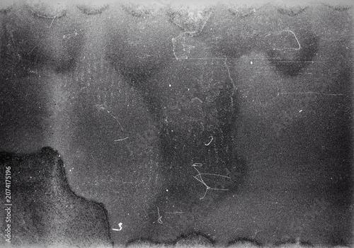 Blank grained film strip texture background with heavy grain, dust and light leak. Old expired soviet moldy photographic film scan. Black and white.