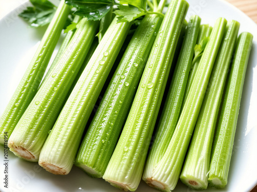 Fresh green celery sticks with water droplets, crisp ribbed texture, and vibrant natural lighting