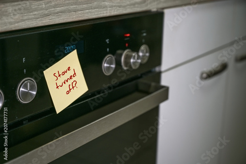 Stove in an old kitchen with a sticky note and reminder text, Stove turned off. Safety concept for dementia or aging forgetfulness in everyday life, copy space